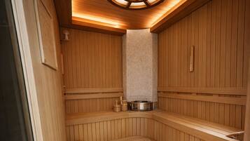 A sauna with wooden walls, a bench, and a circular ceiling light.