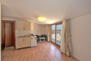 A compact kitchen with a sink, a small refrigerator, and a dining area with a table and chairs. - Taxim Marin Hotel (Istanbul)