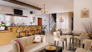 Una sala moderna con un sofá, mesa de centro y una zona de bar con taburetes.