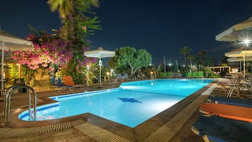 Una piscina al aire libre de temporada, sombrillas