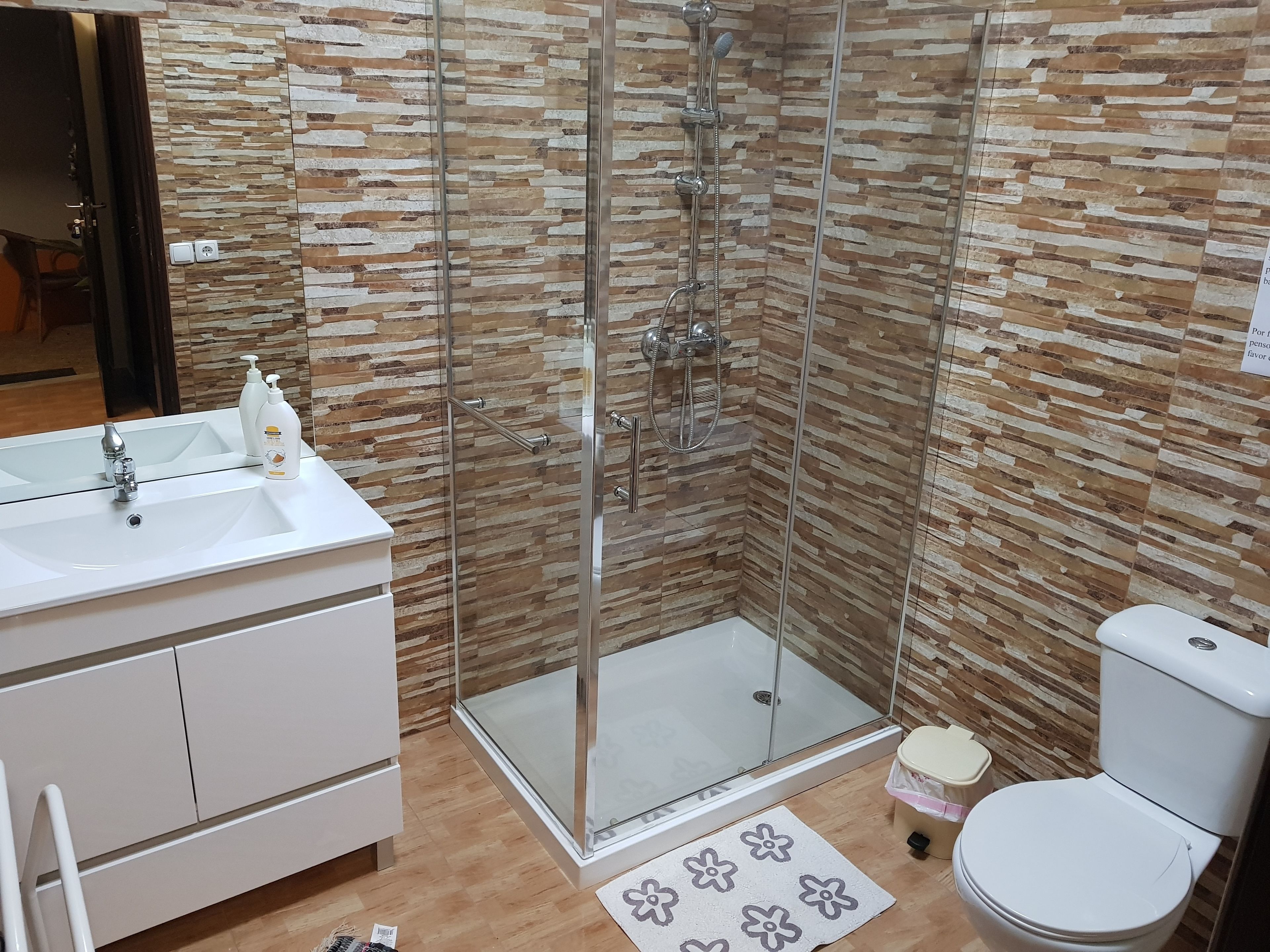 A bathroom with a shower, toilet, and sink.