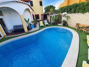 Una piscina al aire libre, sombrillas, tumbonas