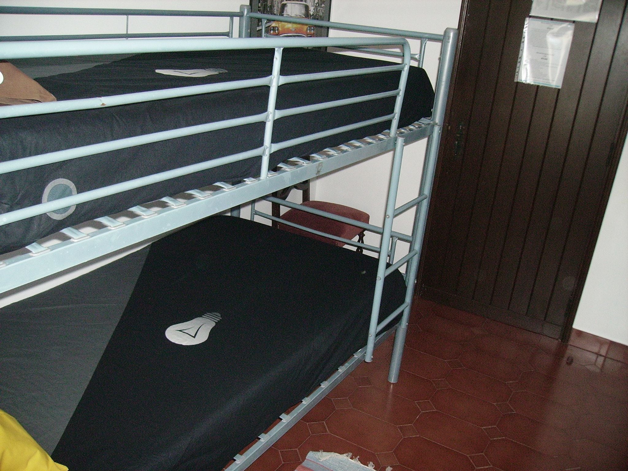 A bunk bed with a mattress and a pillow on the top bunk.