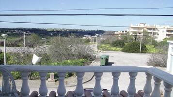 Un balcón con vista a una zona residencial, con casas y vegetación.