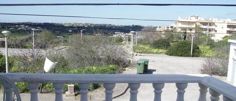 Un balcón con vista a una zona residencial, con casas y vegetación.