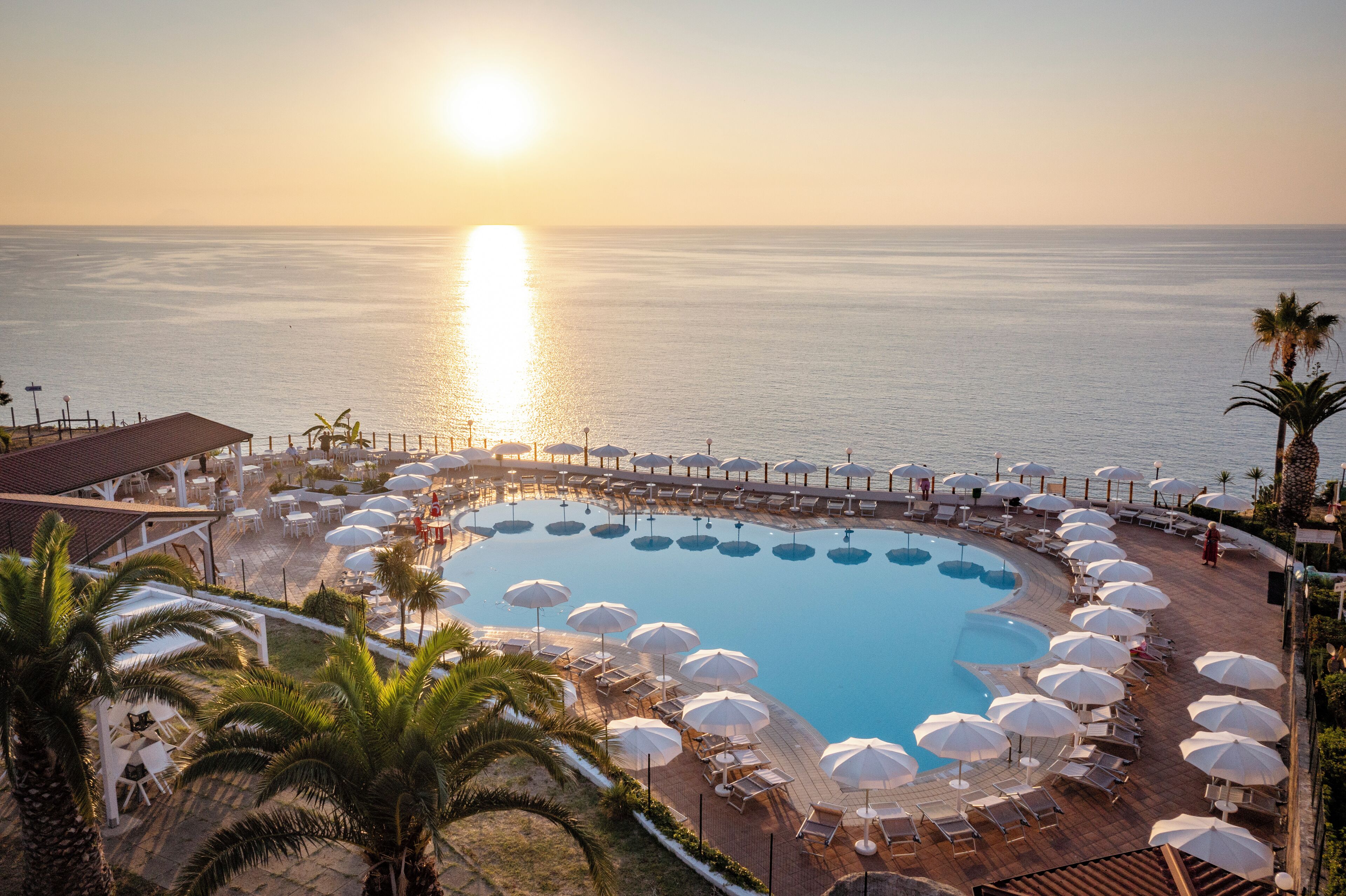 Una piscina al aire libre de temporada, sombrillas