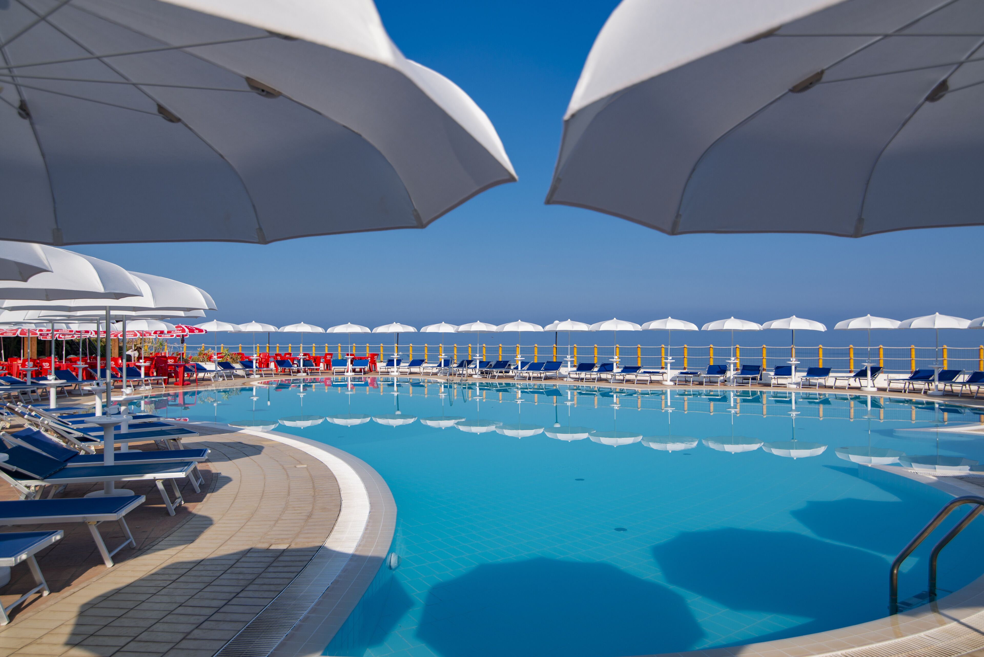 حمّام سباحة خارجي موسمي، مظلات على حمّام السباحة، مقاعد للتشمس