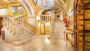Un magnifique escalier en marbre, agrémenté de détails dorés, menant à un deuxième étage.