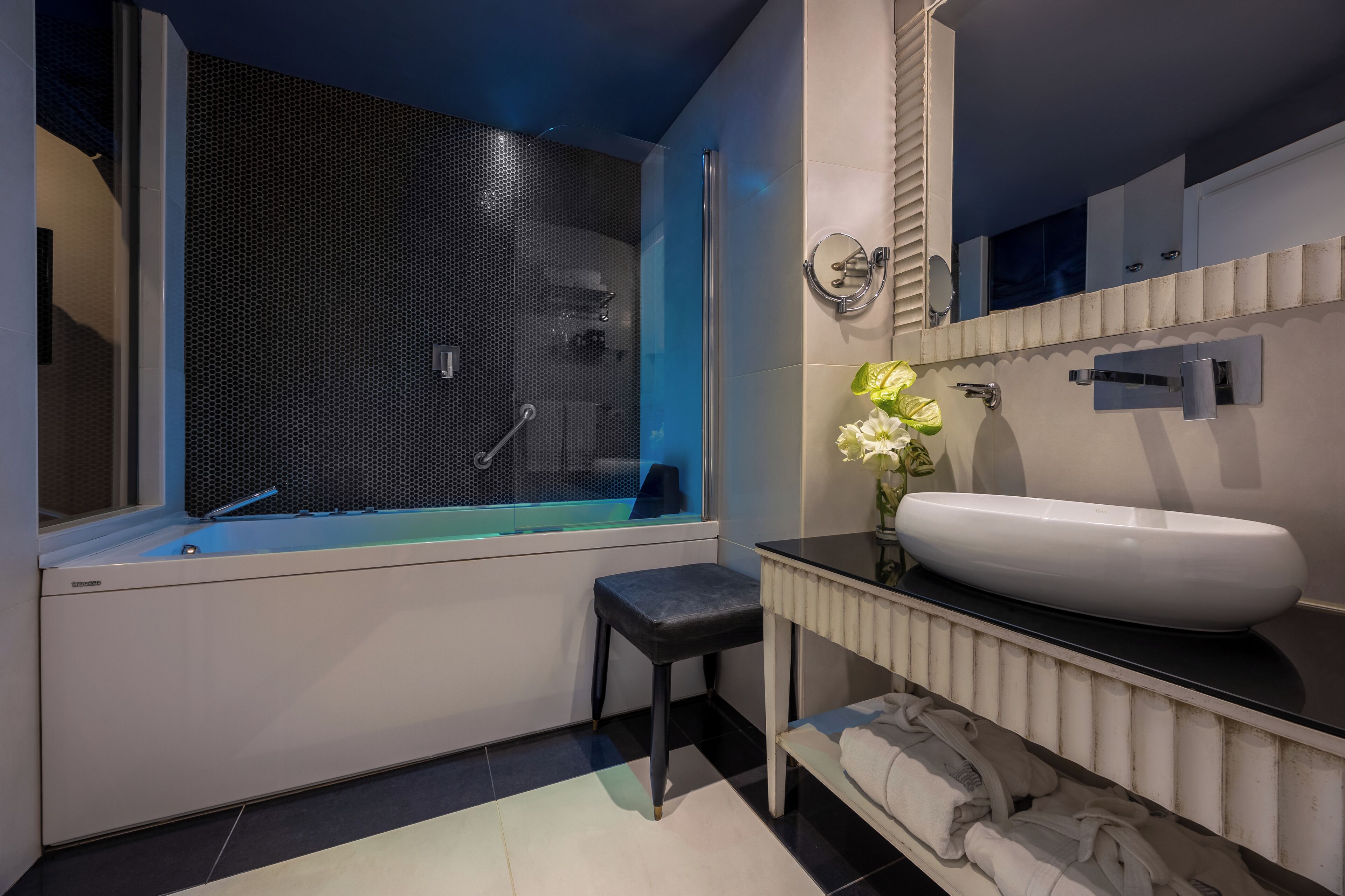 A modern bathroom with a bathtub, a white sink, and a mirror.
