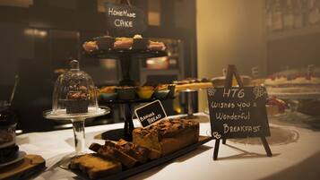 Un bufé de desayuno con diversos productos de panadería y un letrero que dice "HTG WISHES YOU A WONDERFUL BREAKFAST".