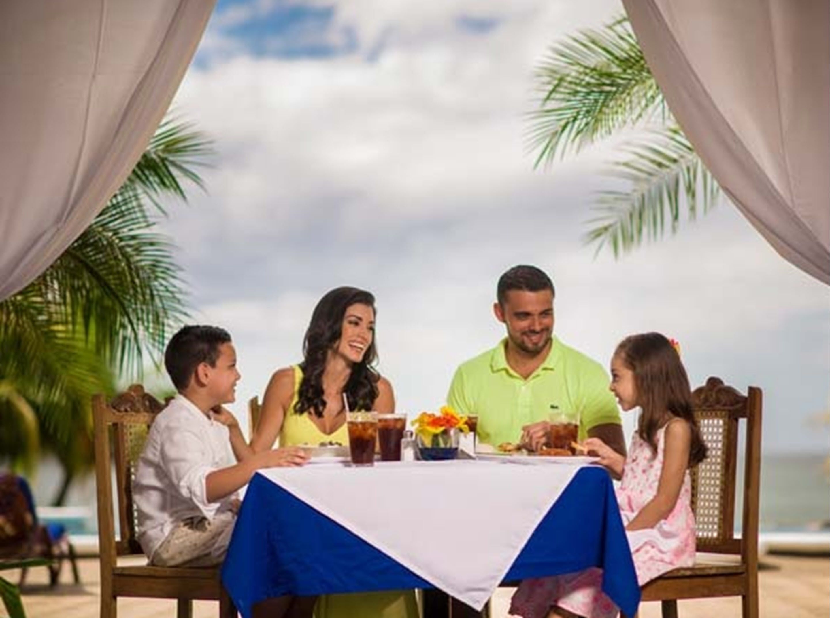 Una familia cenando en una mesa con vista al océano.