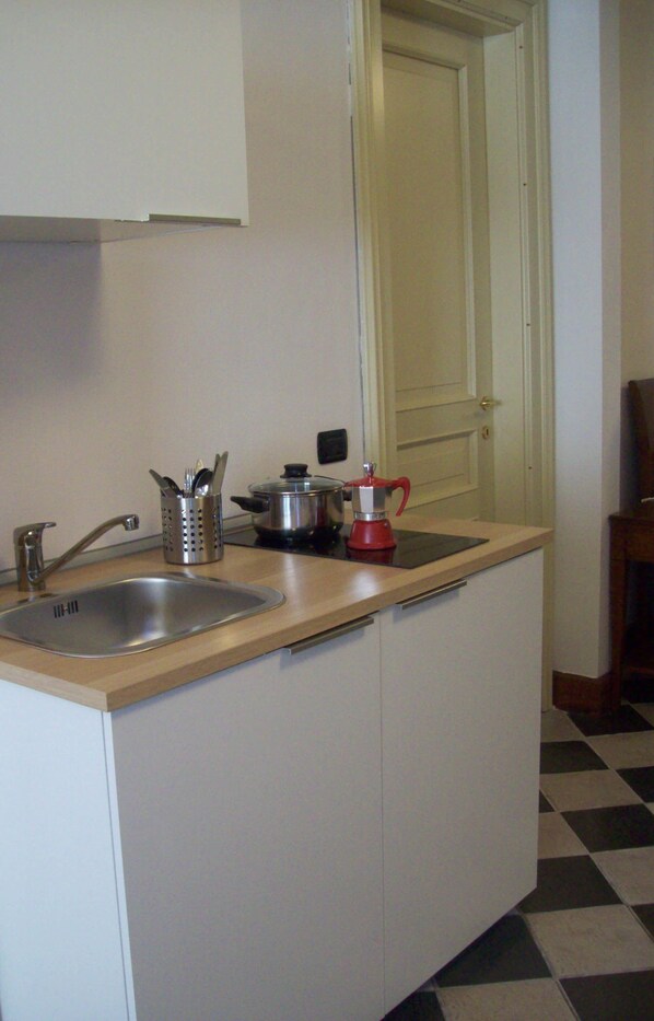 A compact kitchen with a sink, a coffee maker, and a pot on the counter. - Roma Resort Termini (Rome)