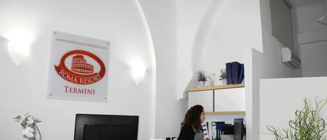 A reception desk at a hotel with a sign indicating it's the Termini location.
