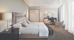 A modern hotel room with a large bed, bedside tables, a desk, and a wardrobe. - DaVinci Suites (Sandton)
