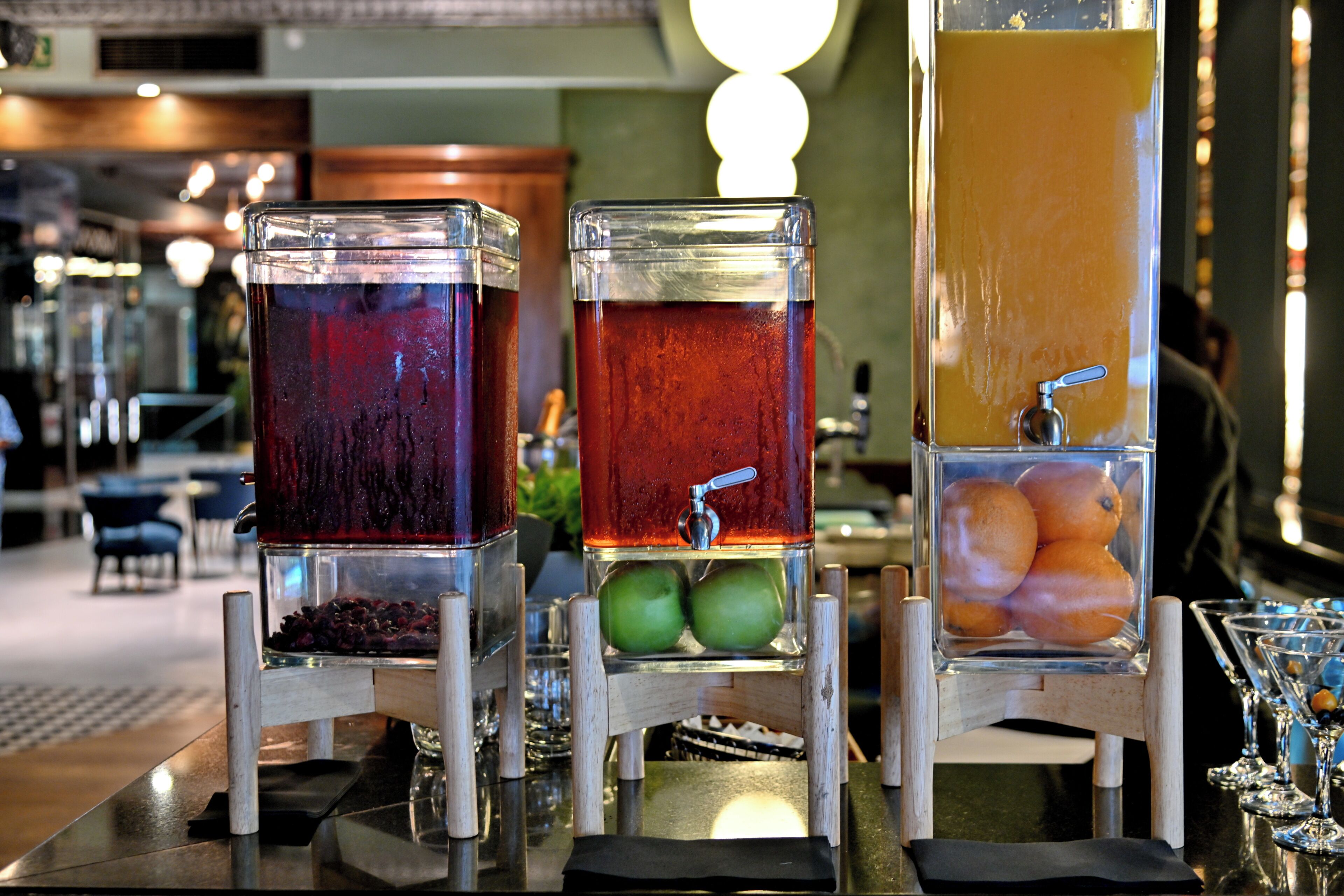 Un espace bar équipé de trois distributeurs de boissons : un pour une boisson rouge, un pour une boisson verte et un pour une boisson orange.