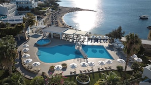 A resort with a large swimming pool, sun loungers, and a beach area. - Sunrise Hotel (Rhodes)