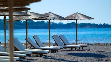 Aan het strand, ligstoelen aan het strand, parasols, een strandbar