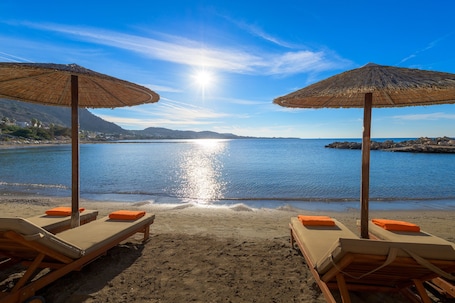 Sulla spiaggia, lettini da mare, ombrelloni, un bar sulla spiaggia. Sunrise Hotel