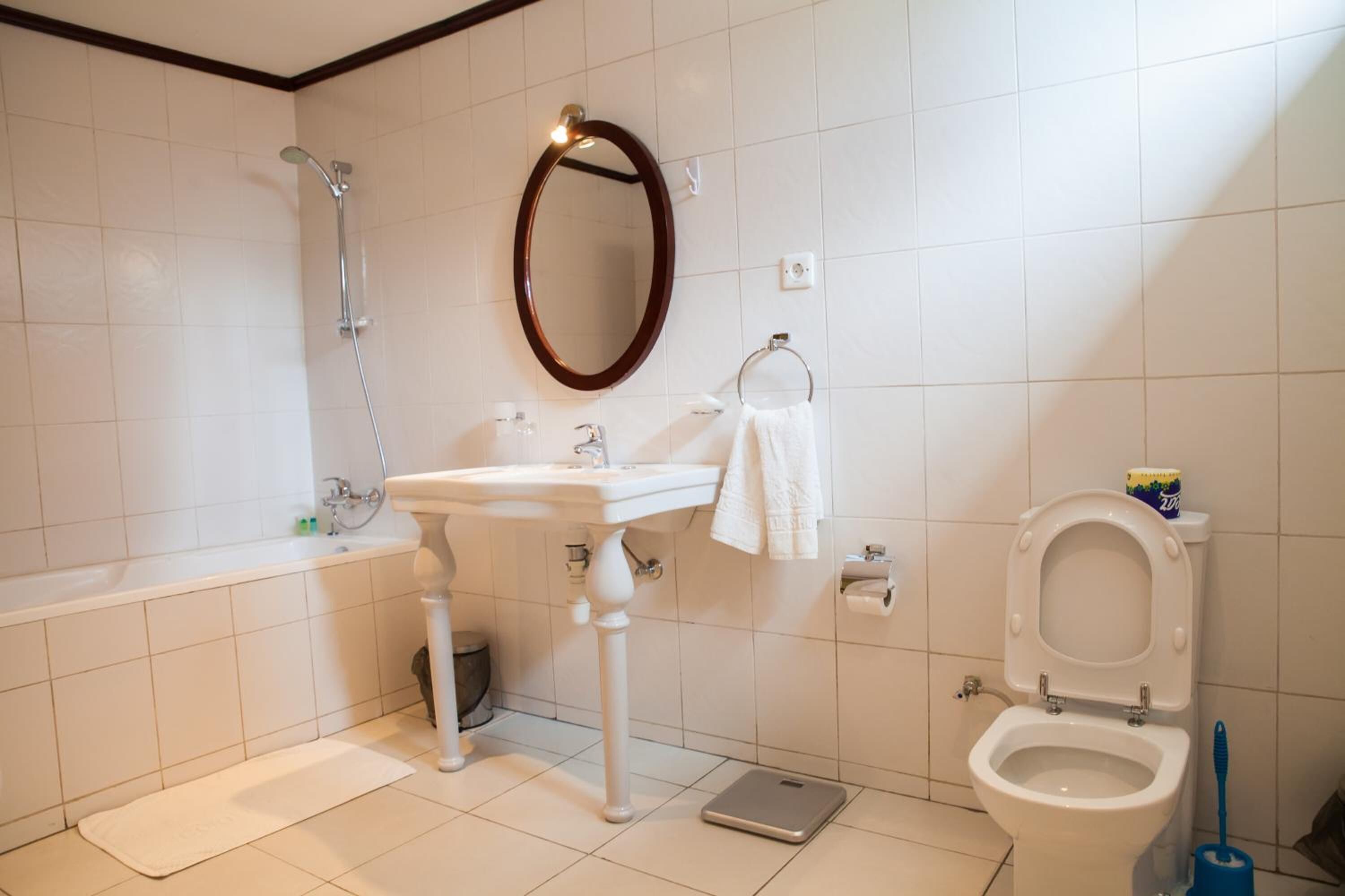 Un baño con bañera, lavamanos, inodoro y espejo.