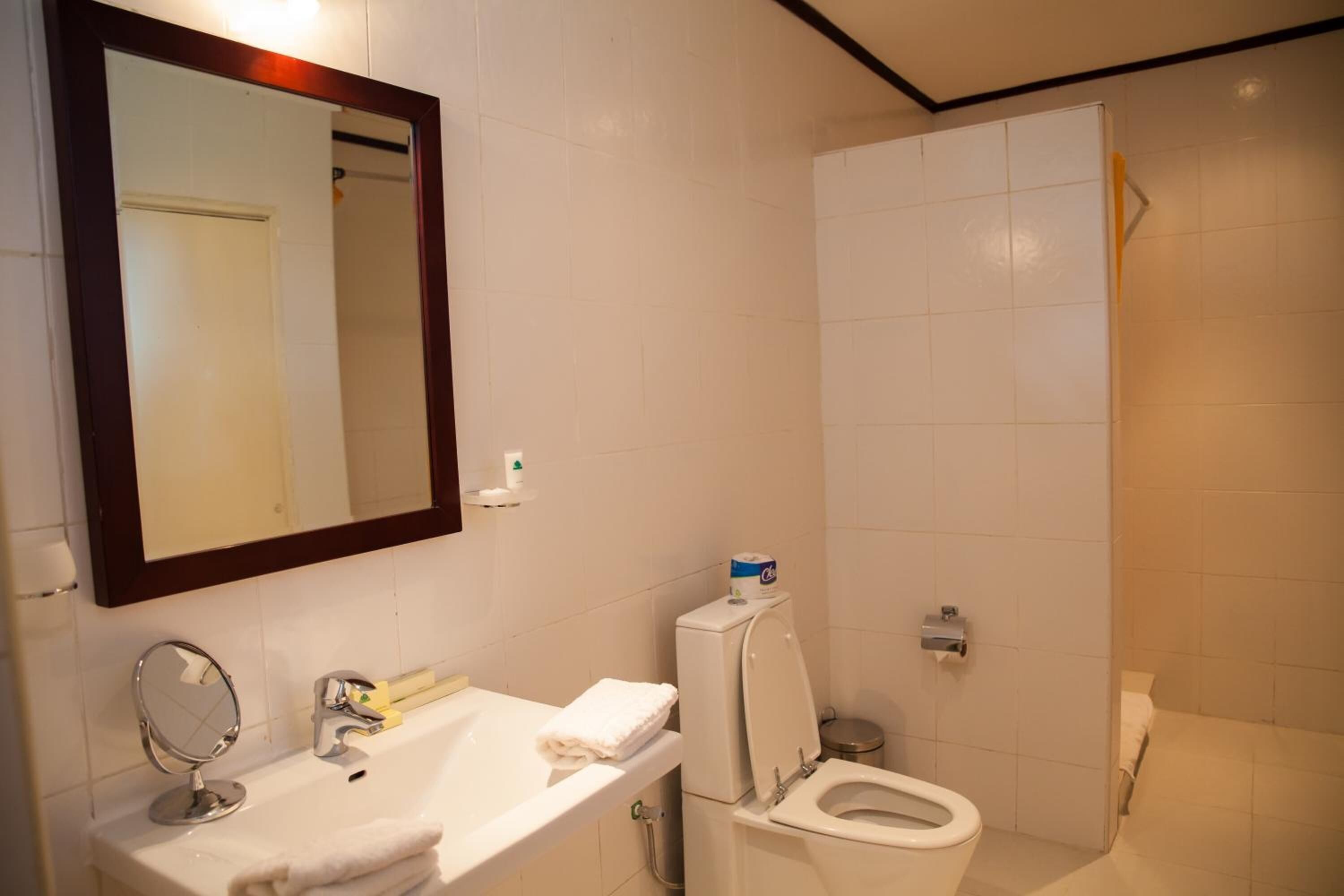 A bathroom with a white sink, mirror, and toilet.
