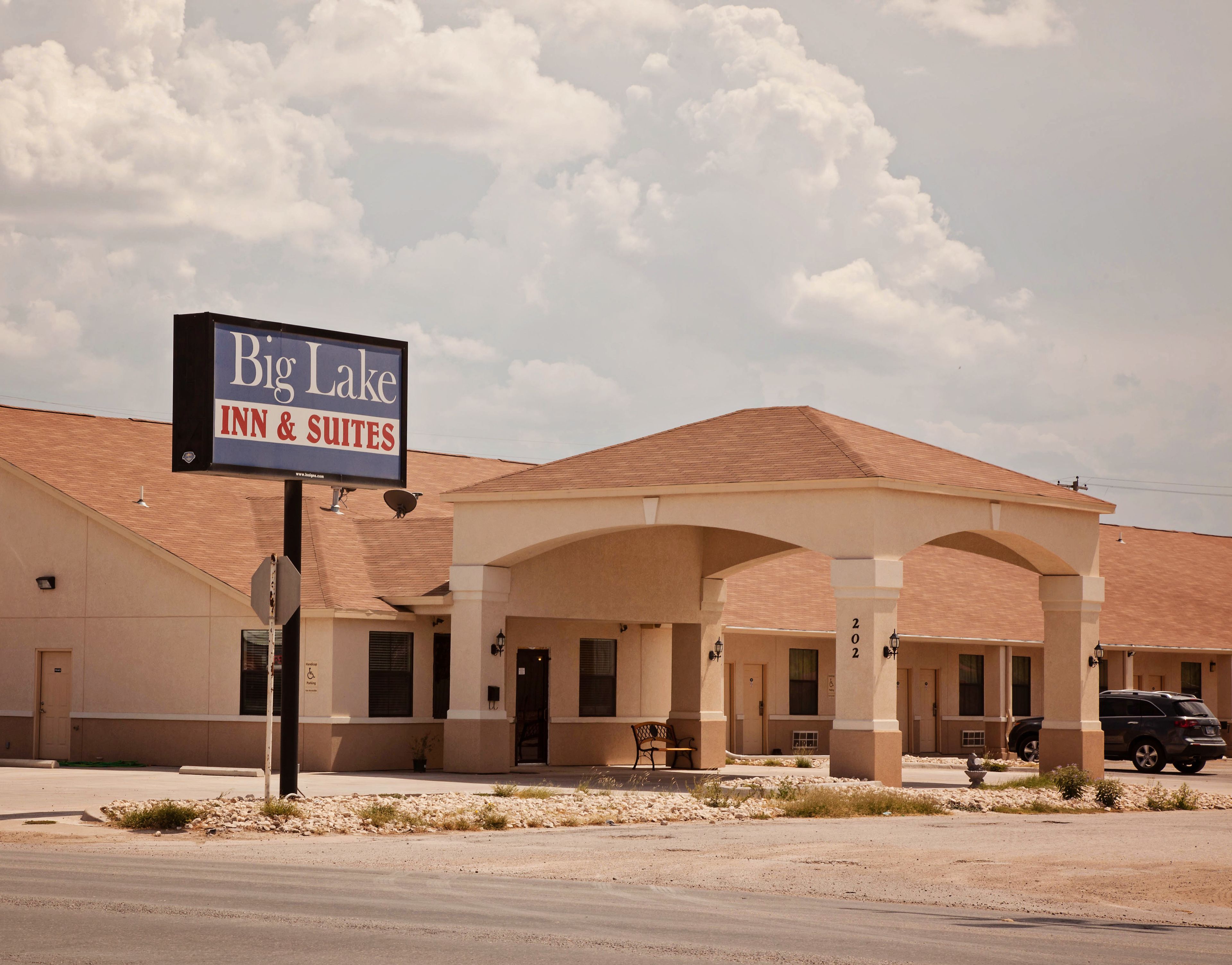 A Big Lake Inn & Suites building with a covered outdoor area and multiple rooms.
