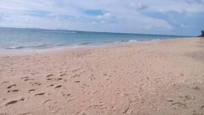 A beach with footprints in the sand and a clear sky. - Funky Fish Hostel (Ko Lanta)