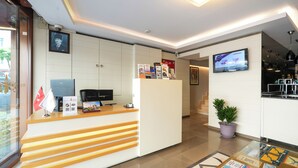 A reception desk with a computer, a flag, and informational brochures.