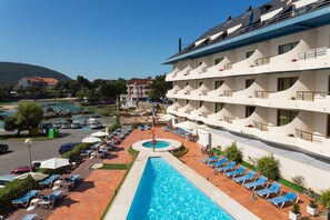 Una piscina al aire libre, sillones reclinables de piscina
