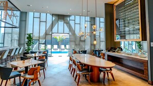 Un área de comedor moderna con una gran mesa ovalada, varias sillas e iluminación colgante.