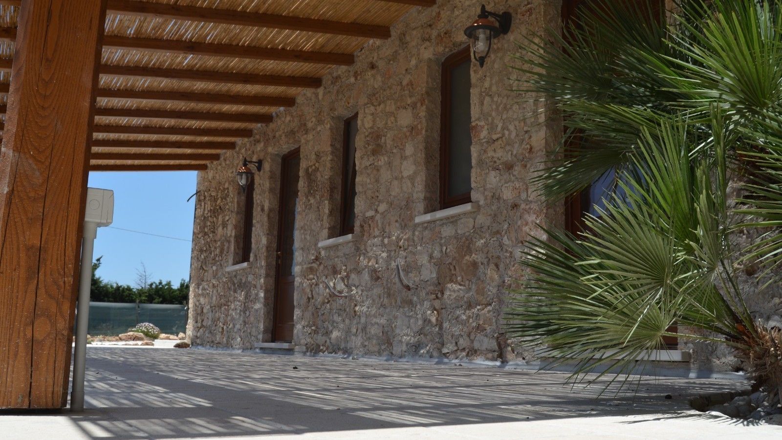 Un edificio in pietra con soffitto in legno e tre finestre.