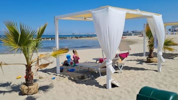 Pantai pribadi di sekitar, kursi berjemur, dan payung pantai