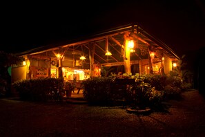 A building with a covered patio area, surrounded by greenery. - Santa Juana Lodge and Nature Reserve (Naranjito)