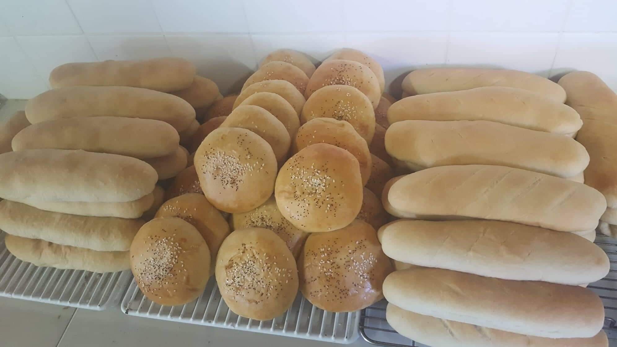 Une variété de petits pains est exposée sur une étagère.