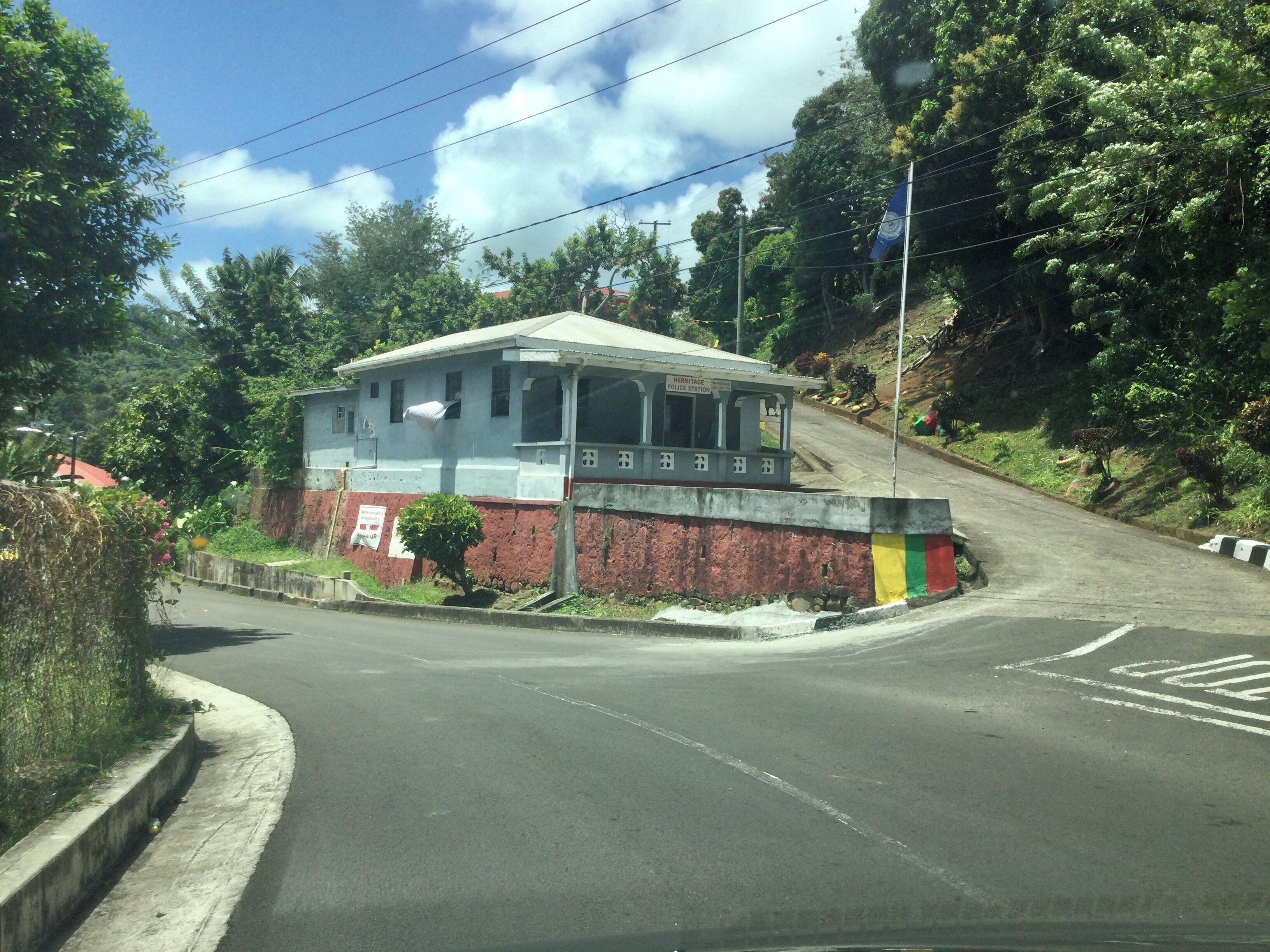 A police station with a two-story building, a red and white exterior, and a sign indicating it is a heritage site.