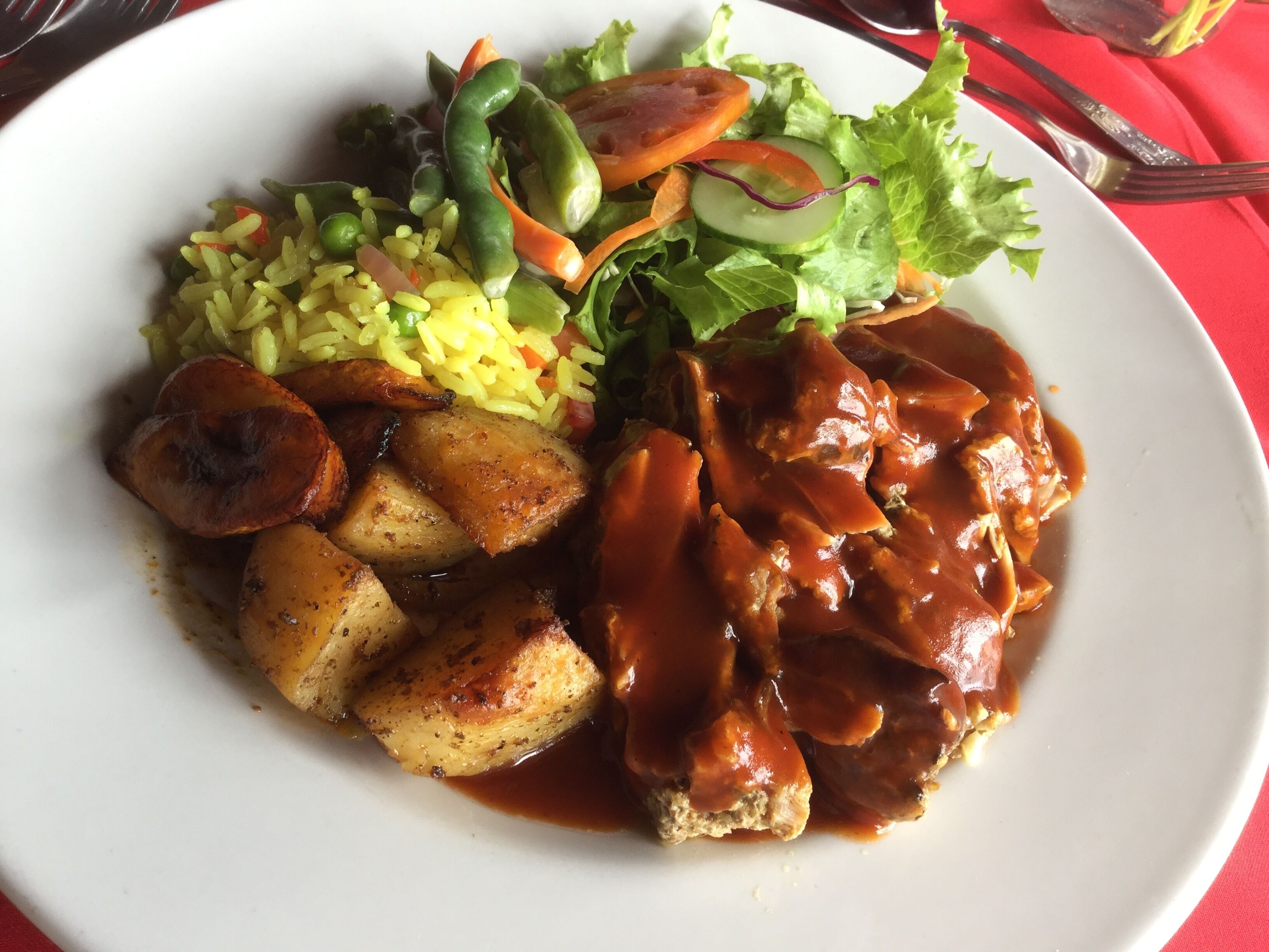 Une assiette de nourriture composée de riz, de légumes et de viande.
