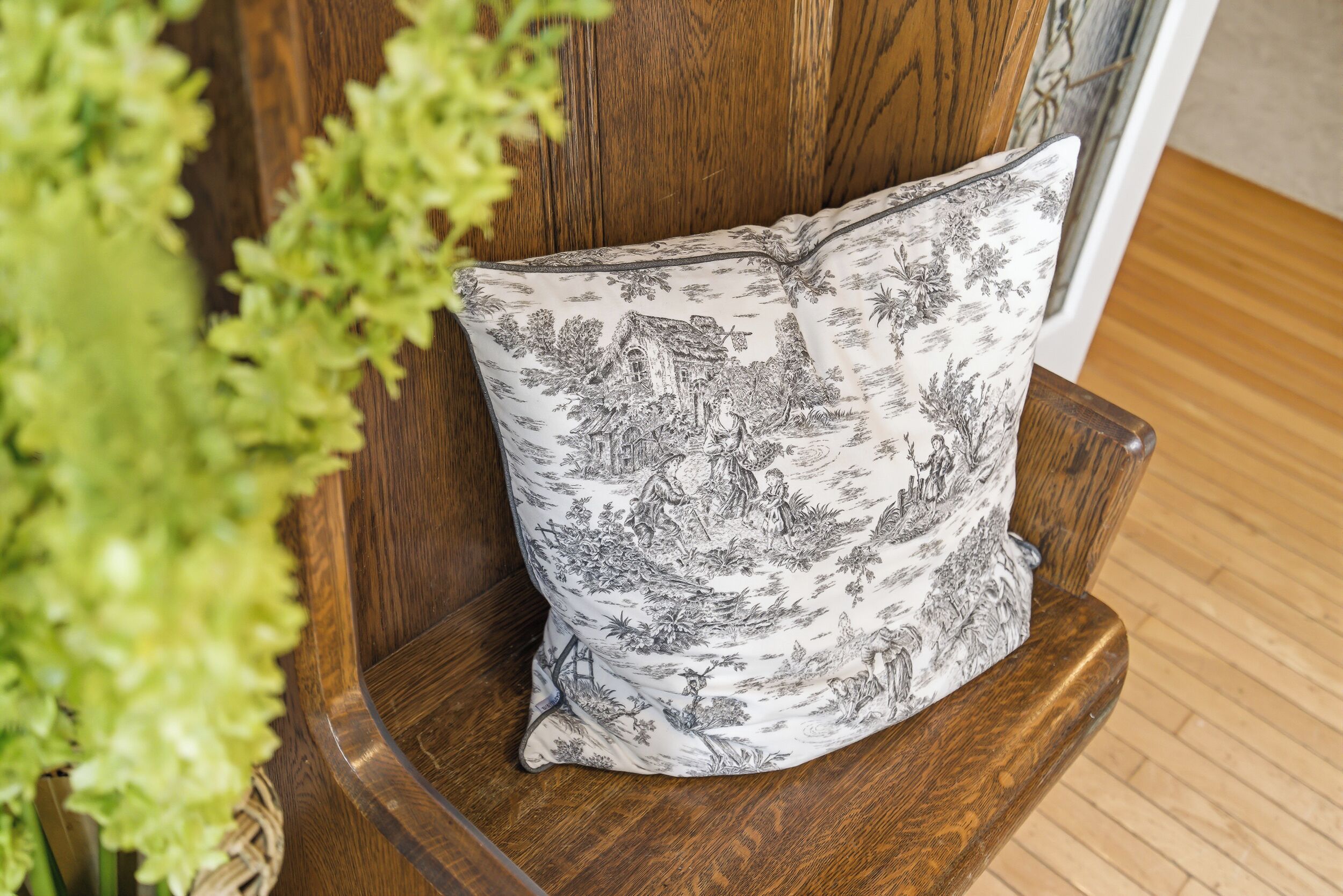 A wooden chair with a floral-patterned pillow.