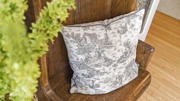 A wooden chair with a floral-patterned pillow.