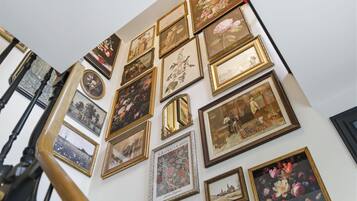 A wall with multiple framed artworks, including a William Morris piece.