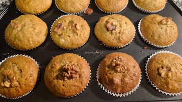 Una bandeja de muffins con nueces sobre una encimera de cocina.