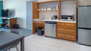 A compact kitchen with a microwave, coffee maker, and dishwasher.
