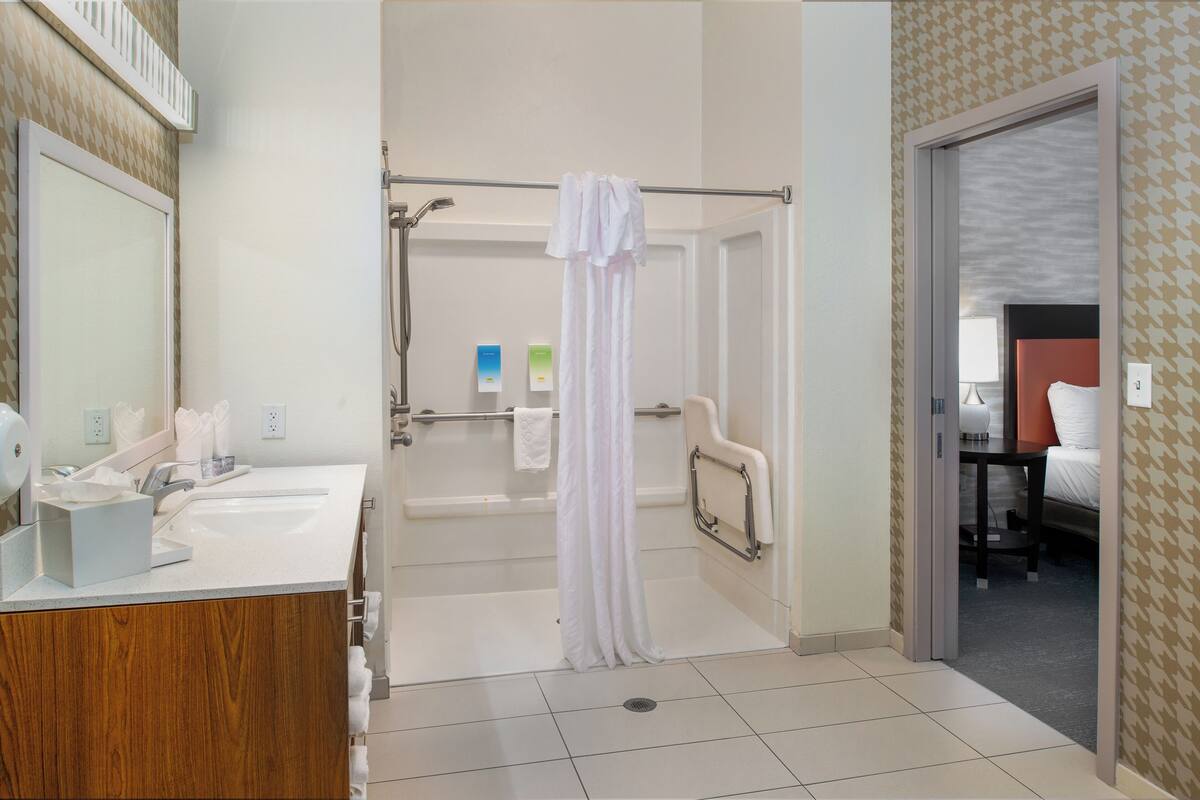 Un baño moderno con ducha, lavabo y espejo.