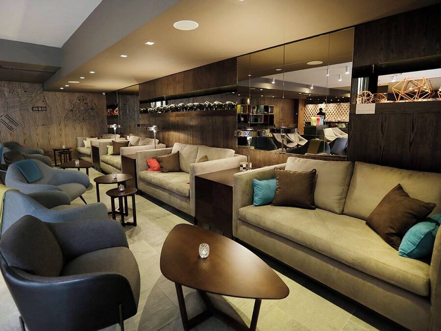 Un área de descanso moderna con sofás, sillones y una mesa de centro.