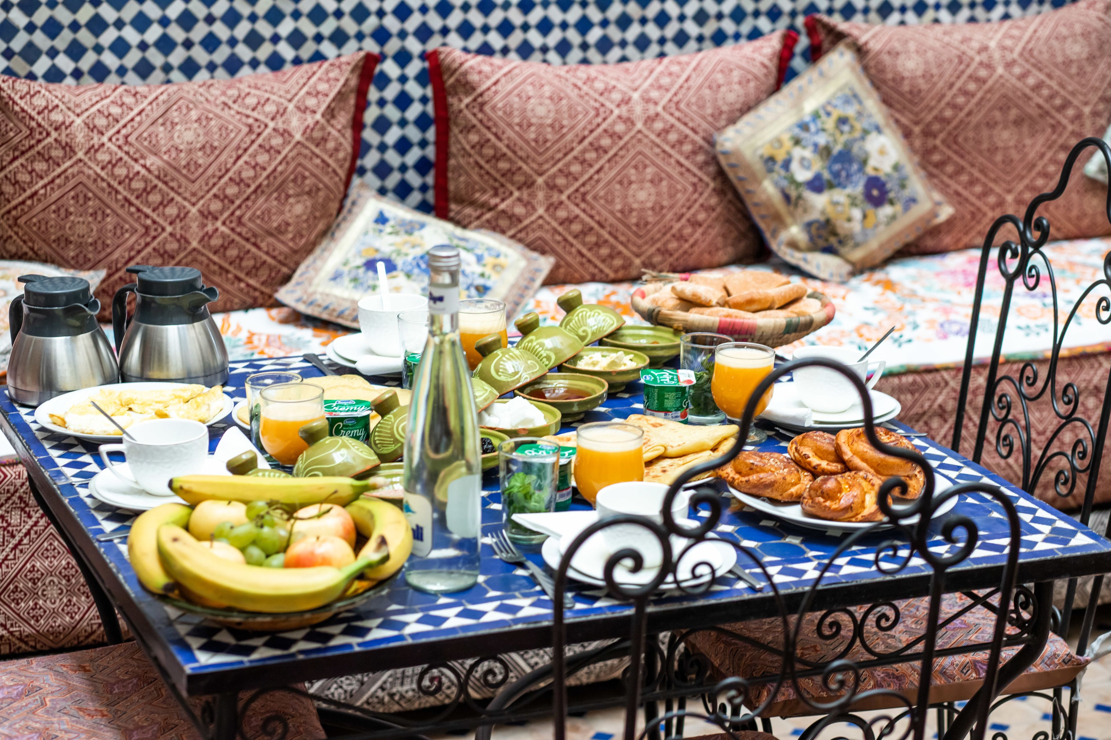 A dining table with a variety of breakfast items including fruits, beverages, and pastries.