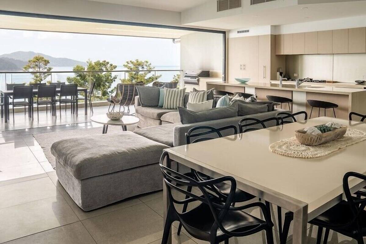 A modern interior with a dining area, sofa, and kitchen.