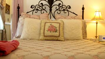 Una cama bien hecha con ropa de cama floral y un cabecero decorativo.