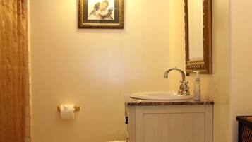 A bathroom with a toilet, sink, and mirror.