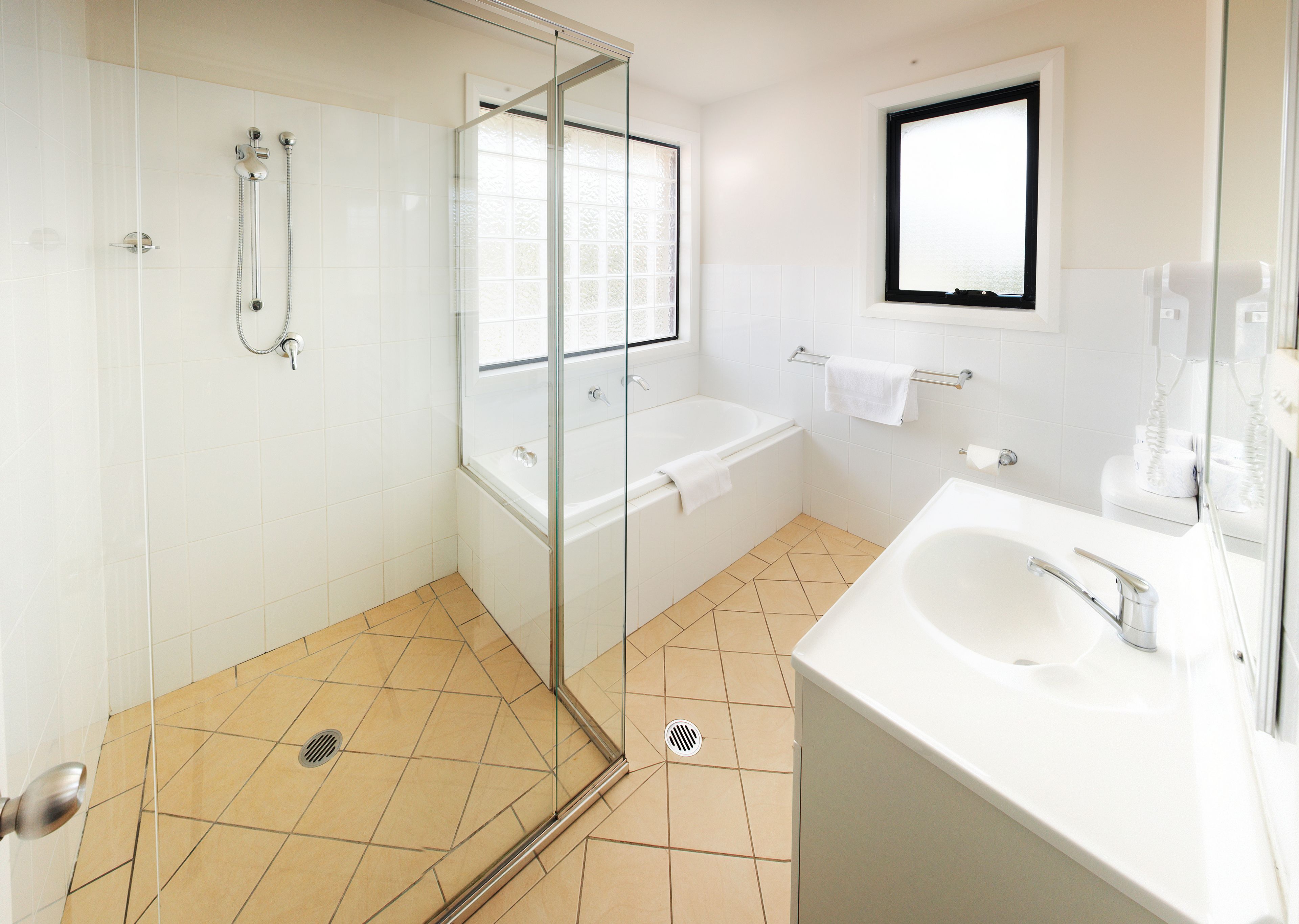 Een aparte badkuip en douche, gratis toiletartikelen, een haardroger