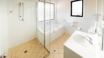 Een aparte badkuip en douche, gratis toiletartikelen, een haardroger