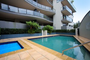 A modern building with a swimming pool, balconies, and greenery. - Nautilos Apartments (Newcastle)
