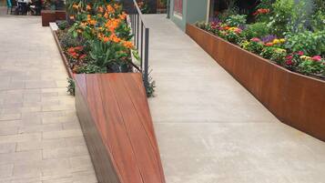 A hotel courtyard with outdoor seating and flower beds.